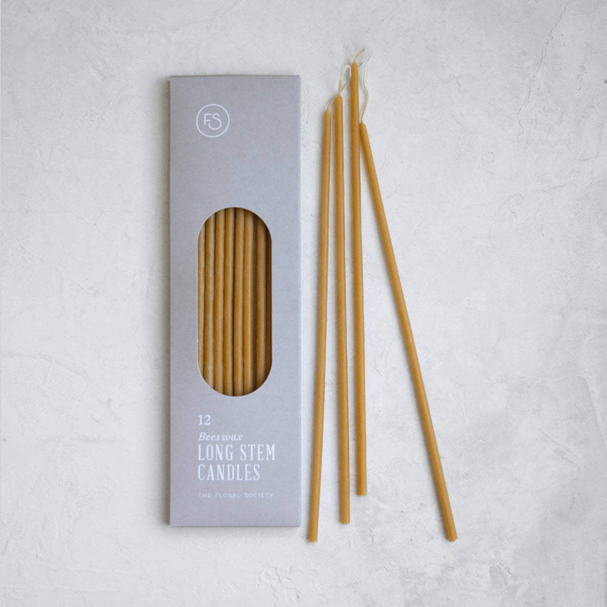 Set of long stem candles with packaging on a light gray background