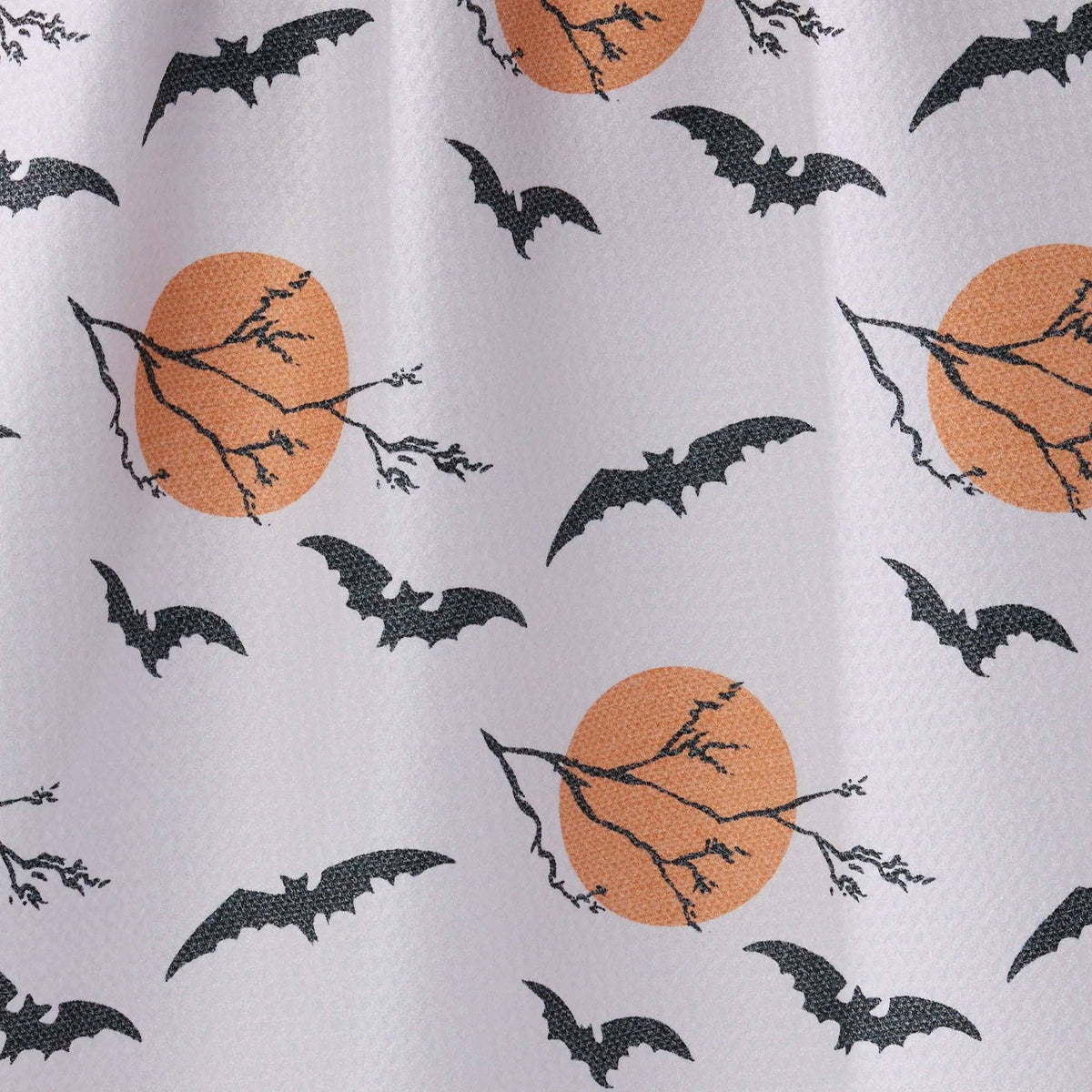 White TEA TOWEL  with a repeating Halloween pattern featuring black bats, bare tree branches, and orange full moons.