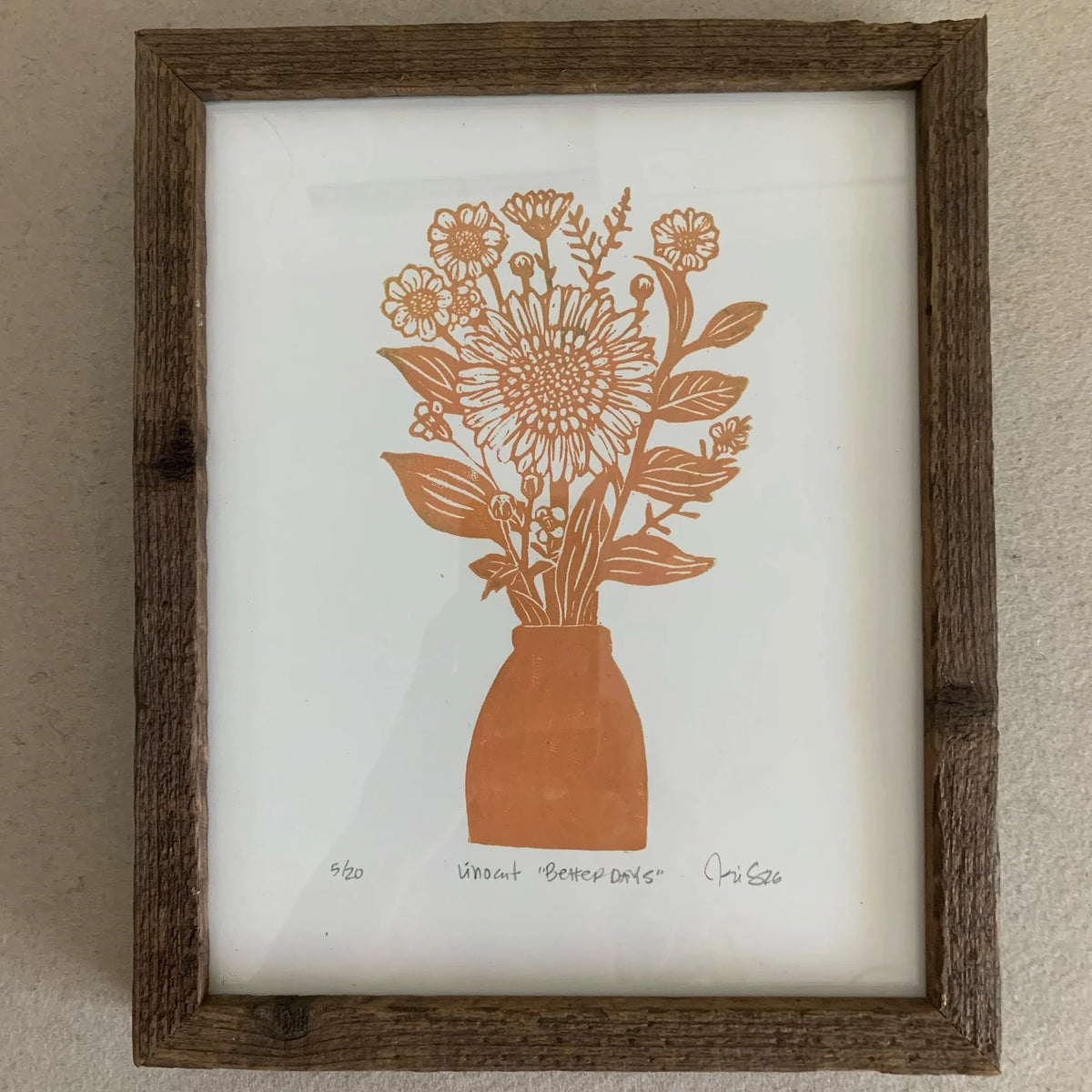 Yellow block print of sunflowers in vase. Print in a rough wooden frame. 