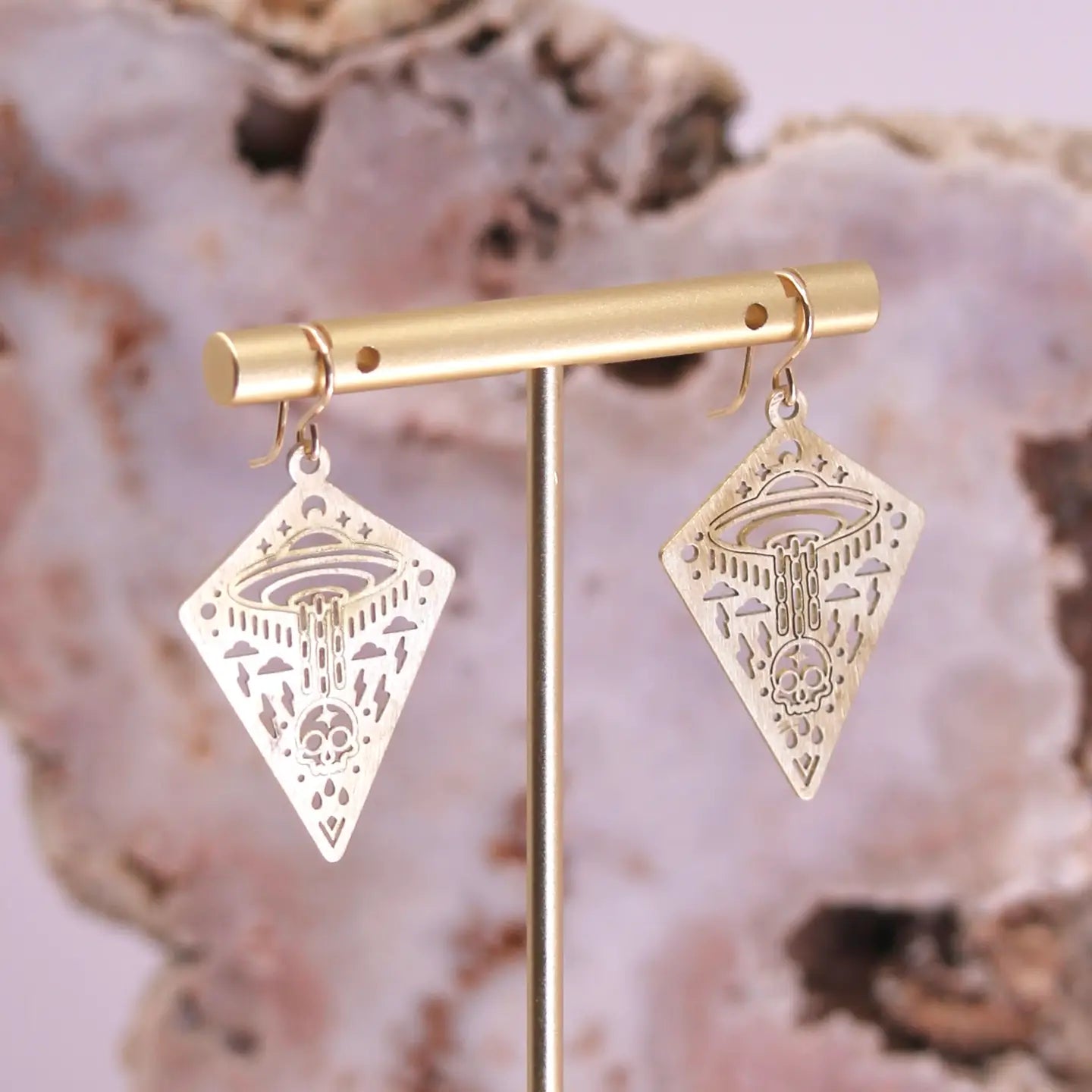 These striking brass earrings showcase an imaginative cosmic narrative—complete with swirling clouds, lightning bolts, and a skull ascending into a UFO. Meticulously crafted through precision laser-cutting, each pair delivers intricate detail without sacrificing wearability. The lightweight construction ensures all-day comfort.

Details:
goldfill earring hooks
laser cut brass charms
25mm x 35mm