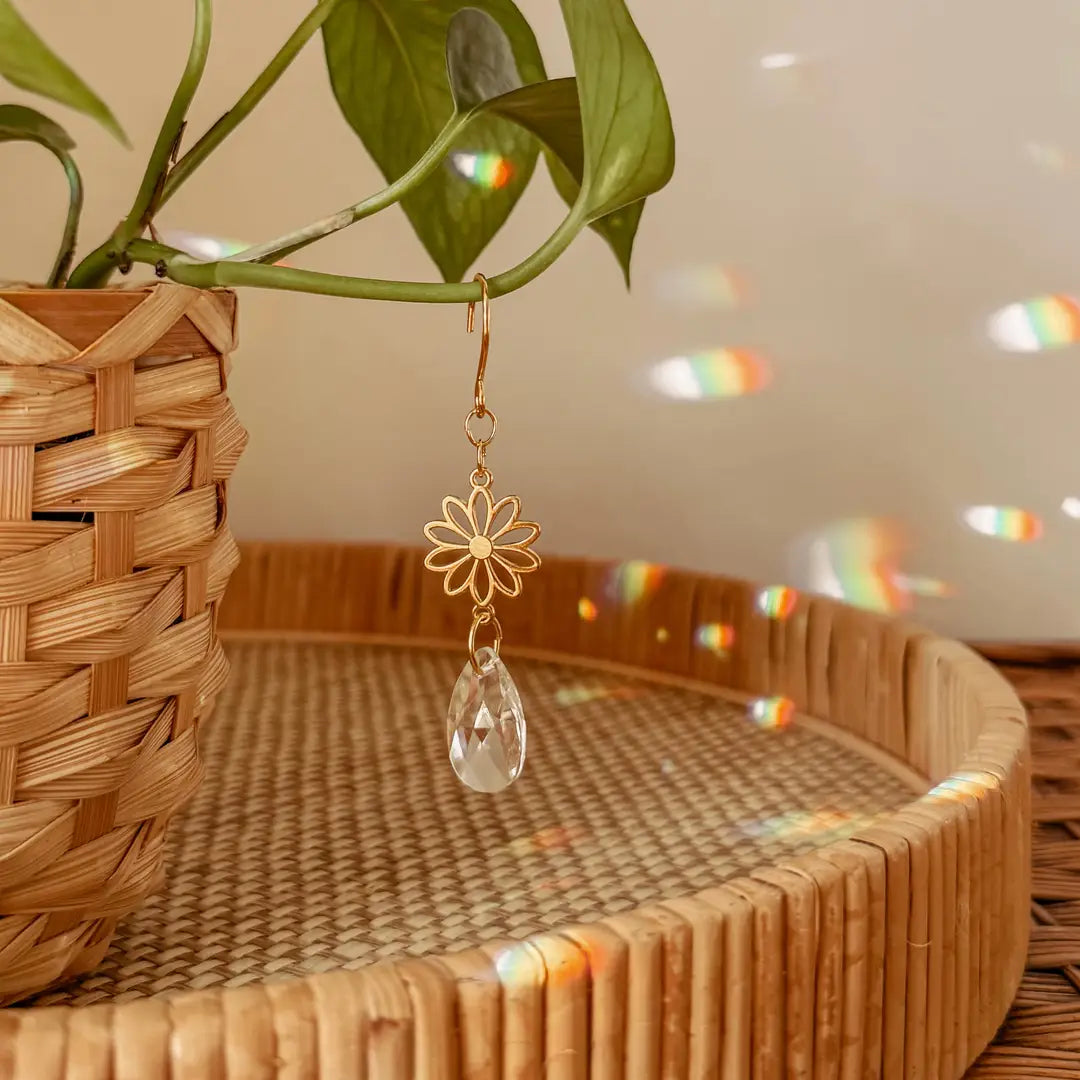 These delicate plant charms hang gracefully from vines, featuring a brass flower charm and suncatcher crystal. As direct sunlight hits the crystals, sparkles dance around to create a dreamy, light-filled atmosphere. Perfect for hanging on vines or trailing plants! Coordinates beautifully with natural, bohemian, minimal, hippie, retro,  whimsical decor styles.