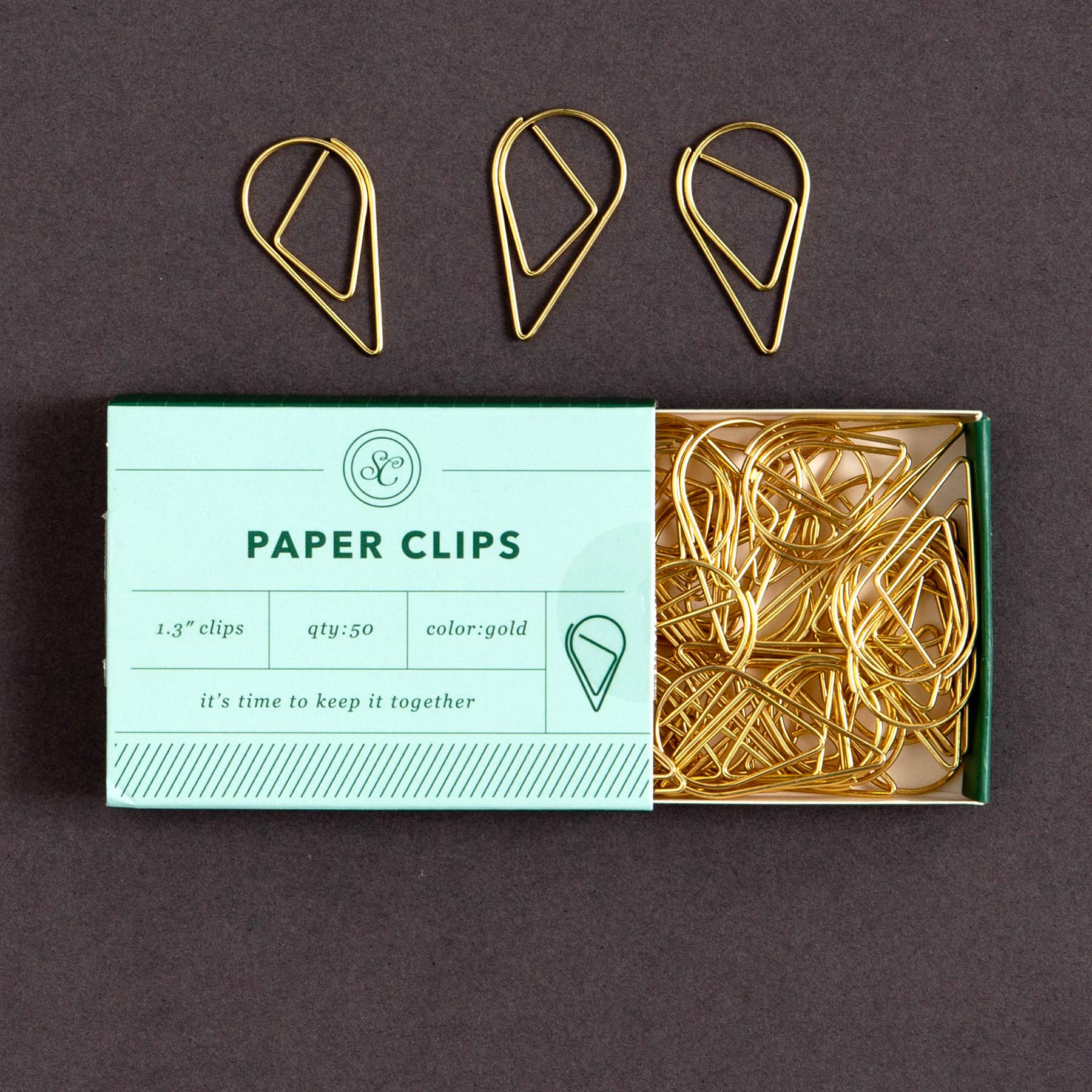 Keep it neat with a playful twist using the Keep It Together Paper Clips. This 50-pack of gold clips comes in a soft blue box with a clever message that’s as functional as it is fun. The unique teardrop shape adds flair to your everyday paper stacks, planners, or project boards—perfect for home offices, classrooms, or journaling setups. A stylish upgrade from standard clips and a charming little gift for students, coworkers, or stationery lovers who like to keep it all together (or at least look like it!).