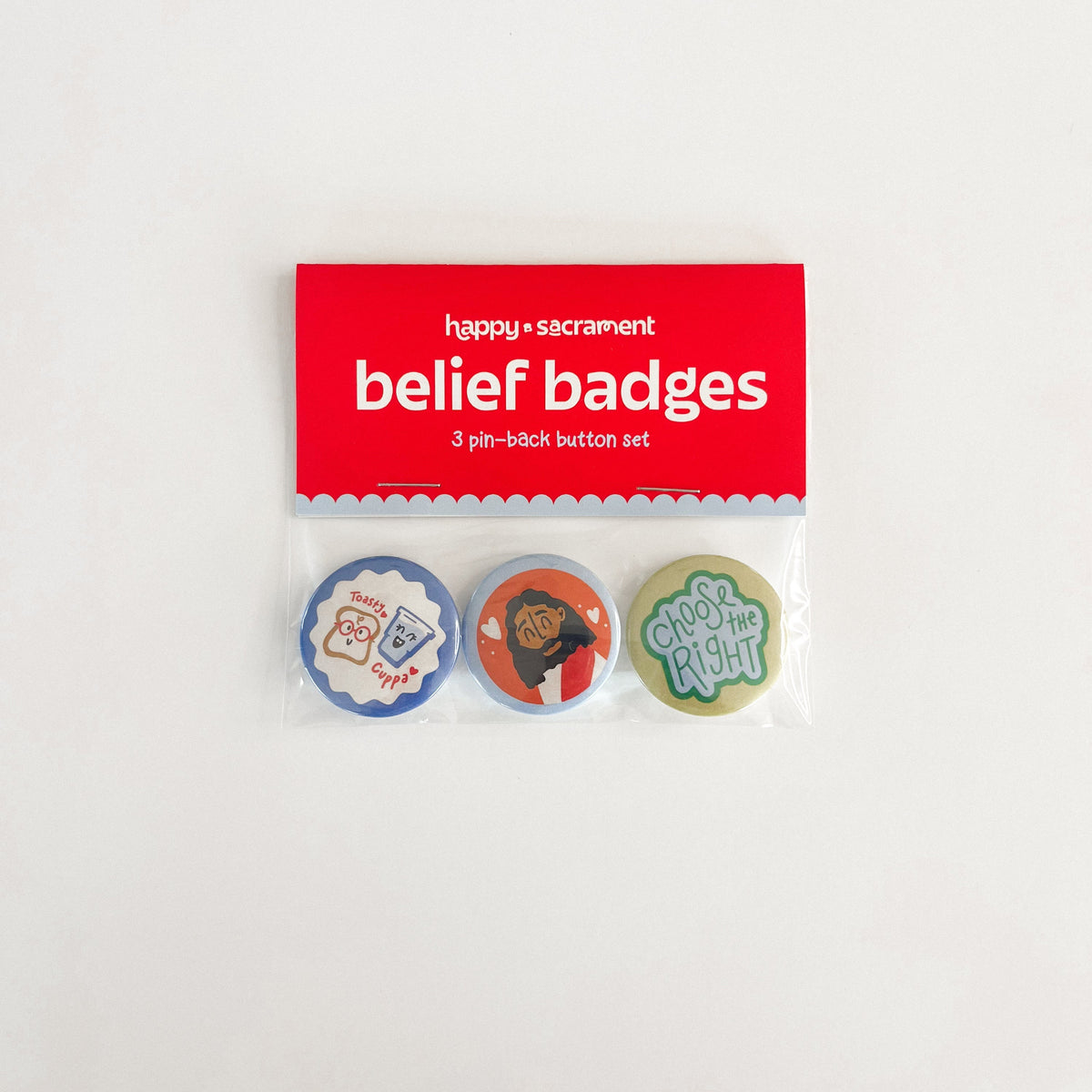 A three-piece “belief badges” pin-back button set is displayed in clear packaging with a red header card. The colorful buttons feature playful faith-inspired designs, including a toast character, an illustrated person, and a “Choose the Right” message.
