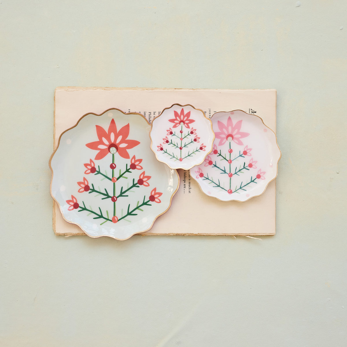 Bring effortless warmth and elegance to your festive entertaining with these Scalloped Holiday Botanical Enamel Trays. Beautifully crafted with charming botanical designs and accented with elegant gold edges, this set of three versatile sizes provides a delightful way to serve seasonal treats or display your favorite holiday decor. A thoughtful addition to your home, these trays are designed to bring joy, comfort, and togetherness to all of your holiday gatherings.