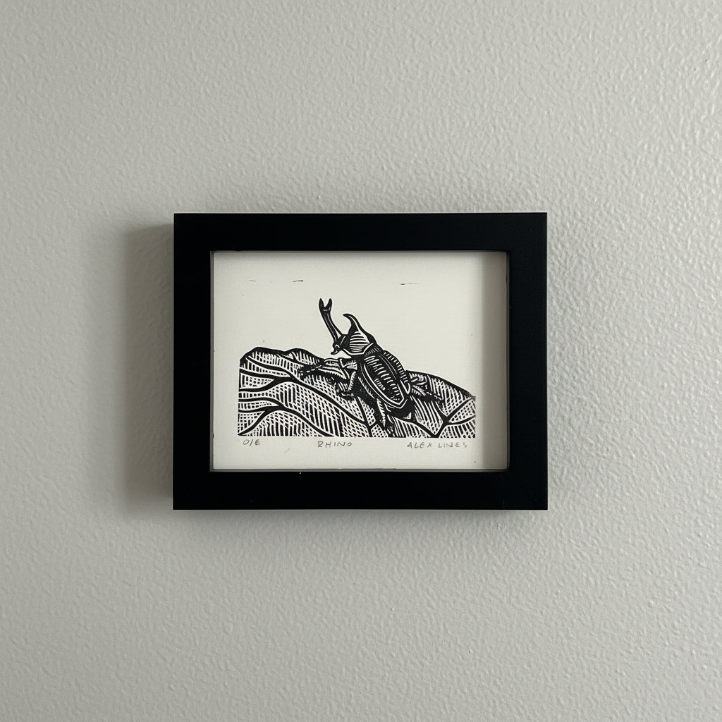 This striking linocut print captures the magnificent Rhino Beetle in bold, graphic detail. Hand-carved linoleum creates dramatic contrasts and intricate textures that bring this armored insect to life. Perfect for nature lovers, art collectors, and anyone who appreciates the quirky beauty of the natural world. Each print showcases the unique character of traditional printmaking, making it a conversation-starting addition to any space. Frame it solo or pair it with other wildlife prints for an eclectic galle