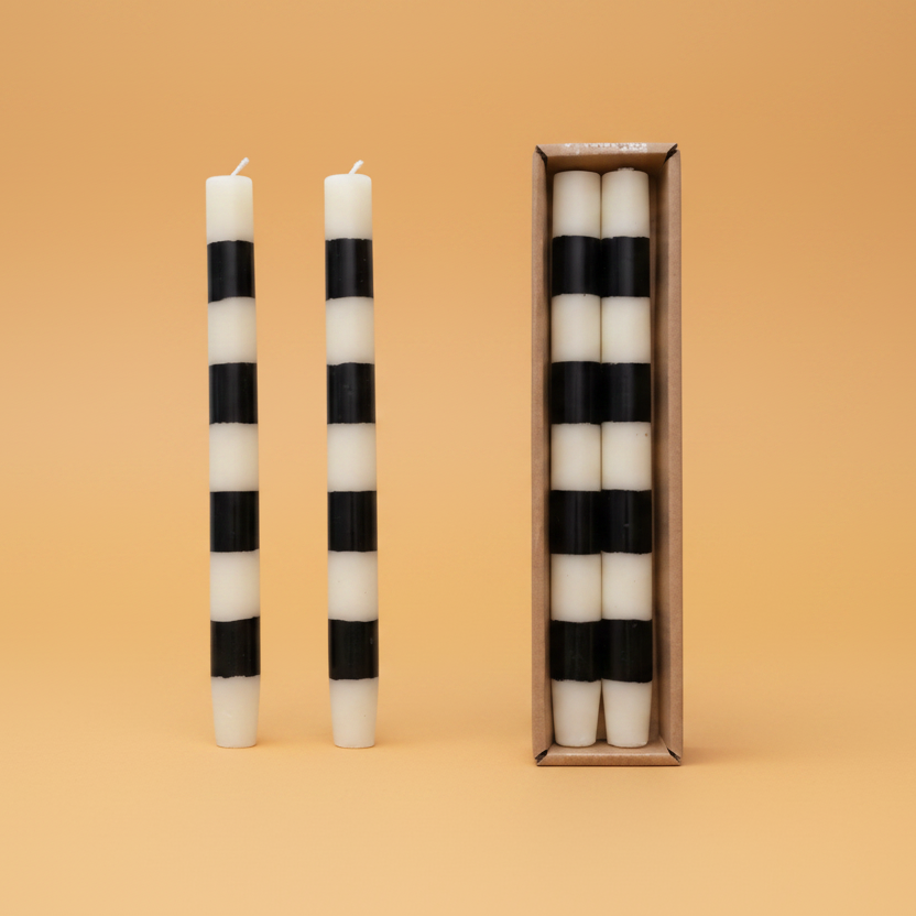 Set the mood with our Unscented Taper Candles featuring playful stripes. Includes a set of two candles in a convenient box. No need for overpowering scents, just enjoy the warm, flickering light. Perfect for any occasion, without taking itself too seriously. Black &amp; White Stripes