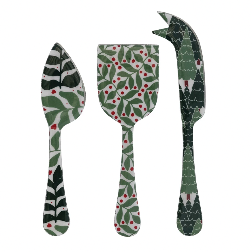 Set of three patterned cheese knives on a white background