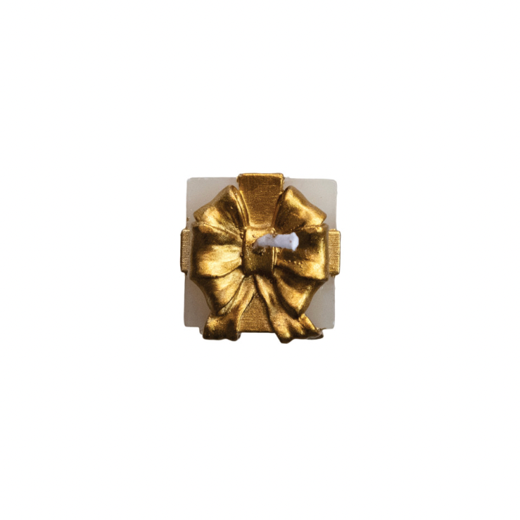 Gold bow on top of candle