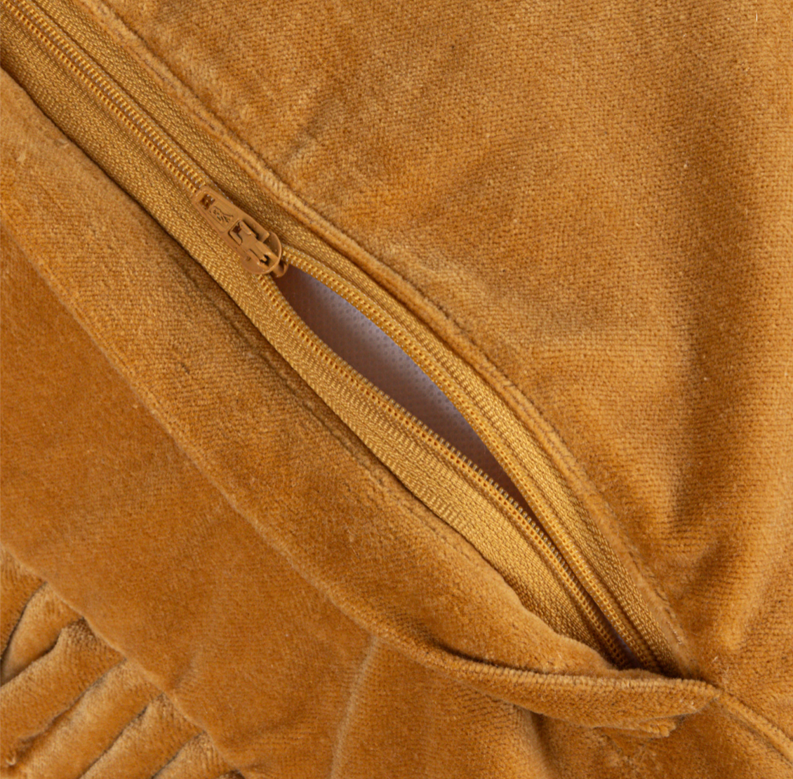 Close-up of a mustard pillow with a zipper