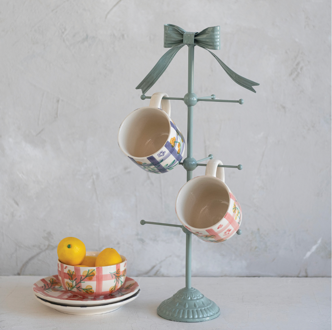 Decorative cup tree with two mugs on a light gray background