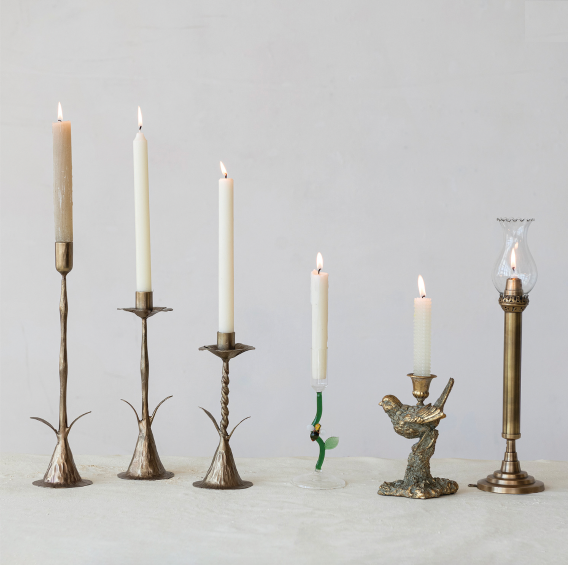 Set of candle holders with candles on a neutral background