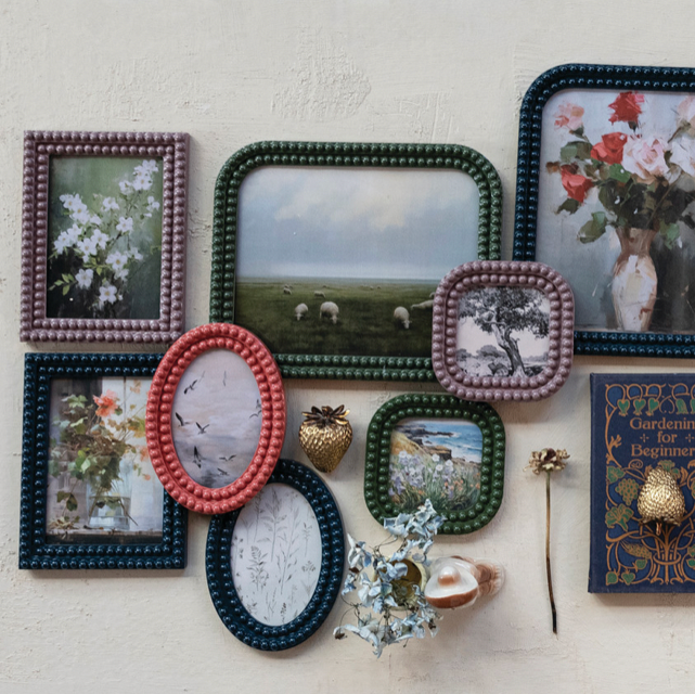 Collection of decorative frames and a book on a white wall