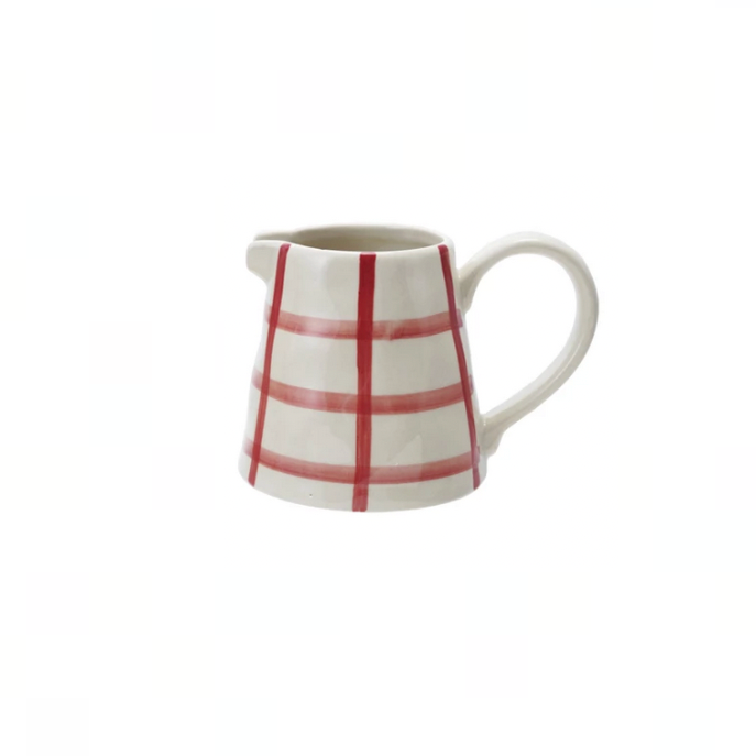 A small white ceramic pitcher with a red grid pattern, set against a plain white background.