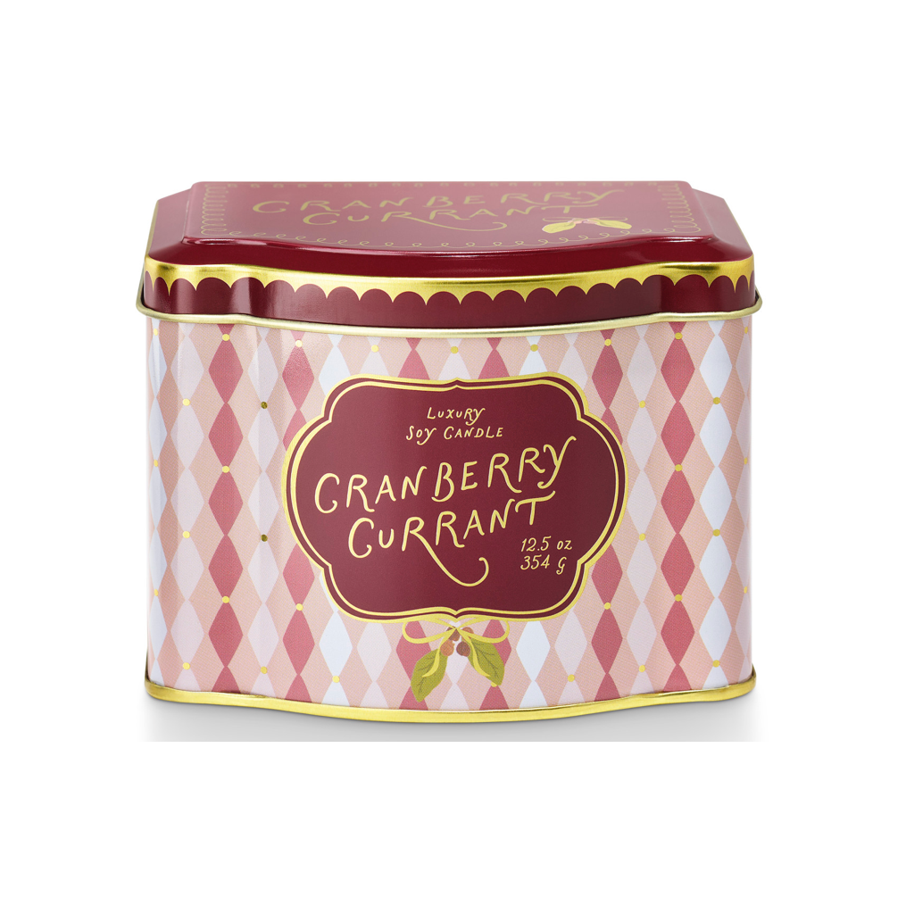A square tin of luxury soy candles by Candle & Co, featuring a pink and white harlequin pattern with a deep red lid and gold lettering that reads 'Cranberry Currant'.