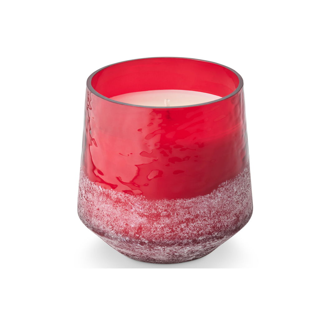 A red glass candle holder with a textured, frosted lower half, containing a white wax candle, shown on a clean white background.