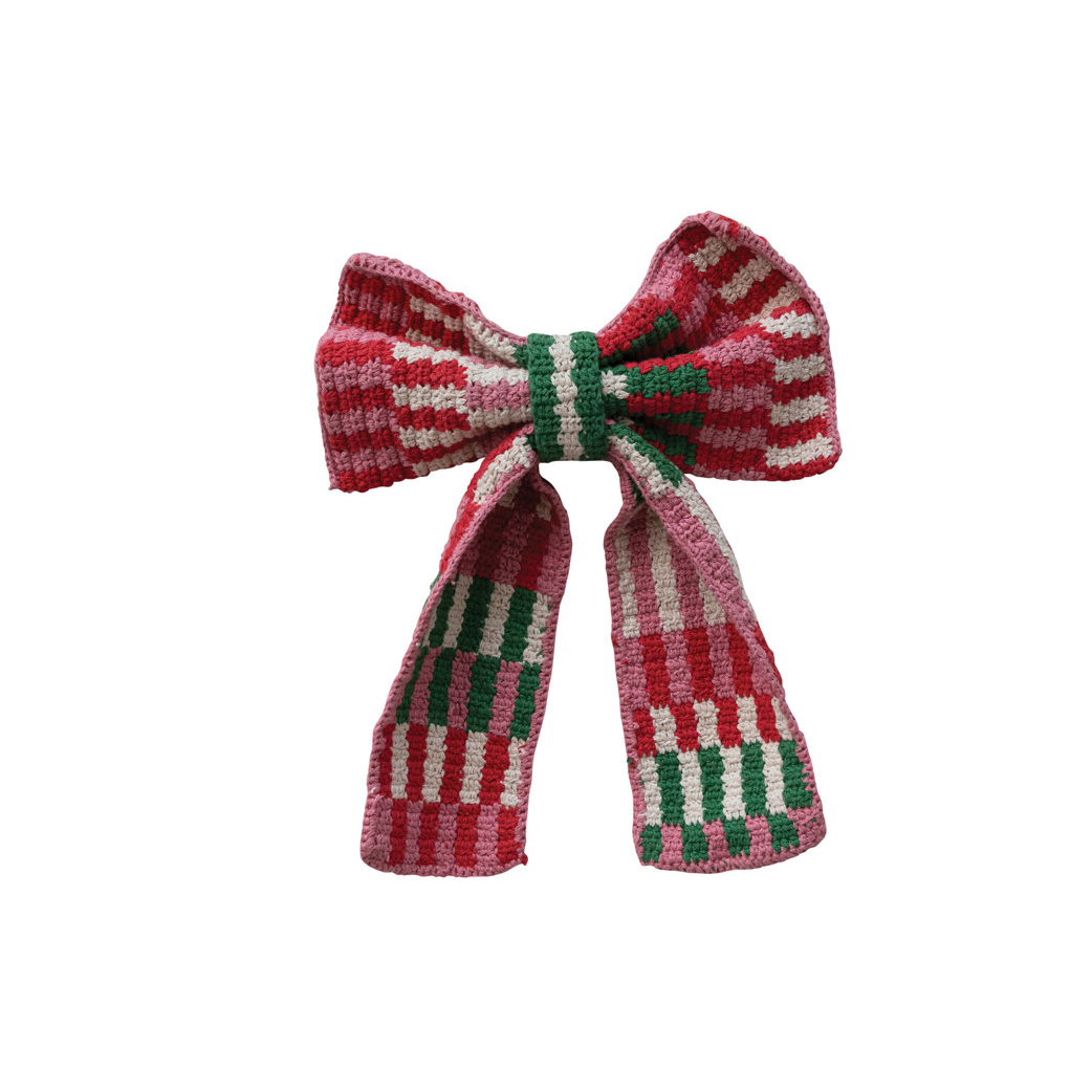 A knitted bow hair clip featuring a festive red, green, and white striped pattern, isolated on a solid white background.