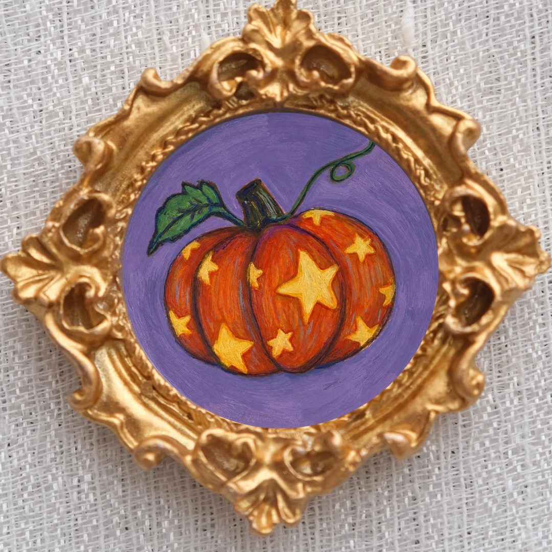Cheerful orange pumpkin with gold stars inside a gold frame magnet. 