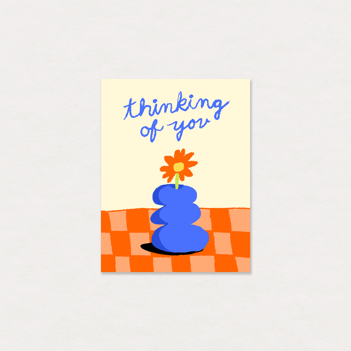 Greeting card with blue vase, flower, and 'thinking of you' text on a checkered background