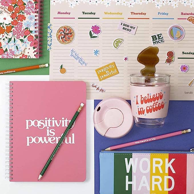 Collage of stationery items including notebooks, a pencil, and a cup with motivational text.