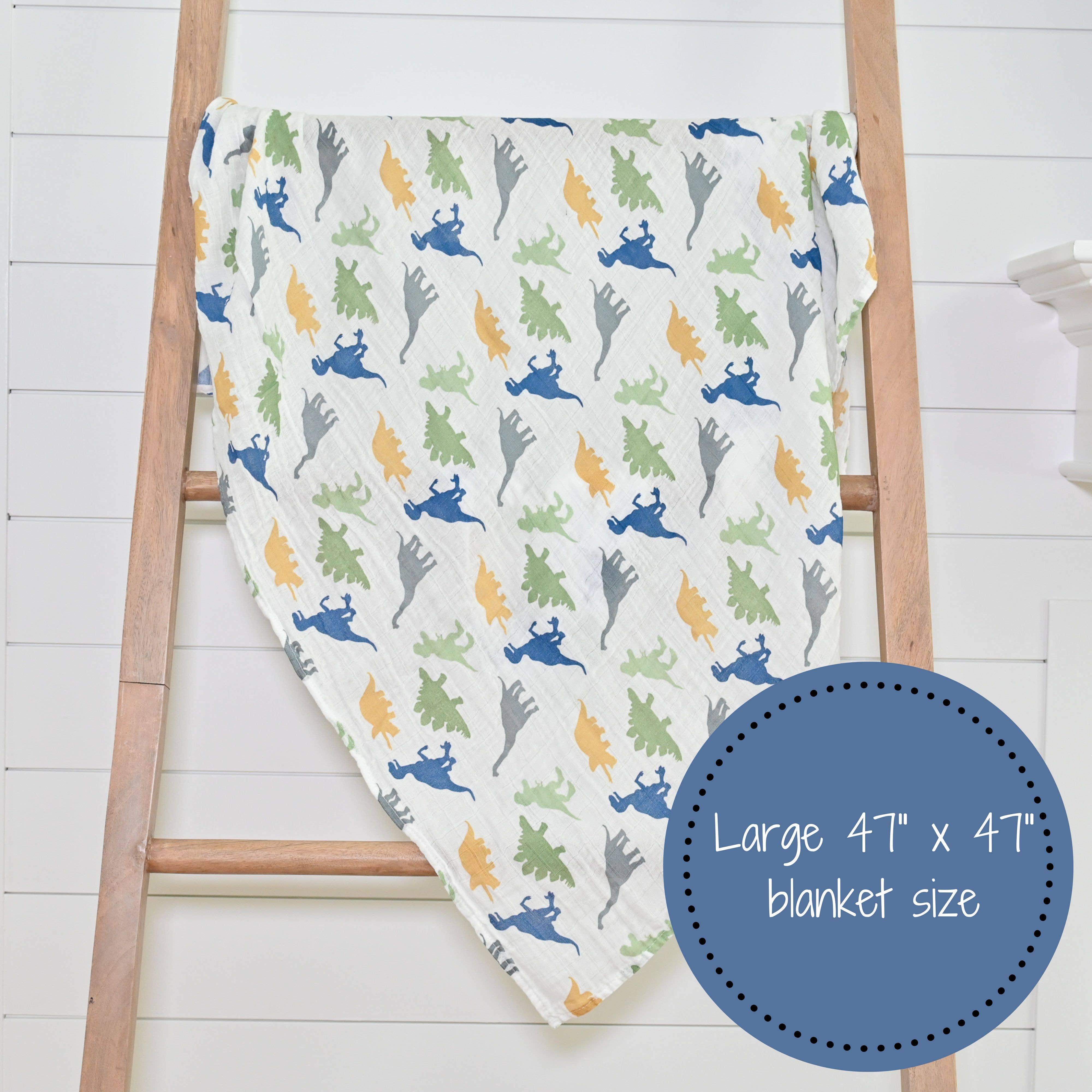 Blanket with colorful dinosaur pattern draped over a wooden ladder on a white background