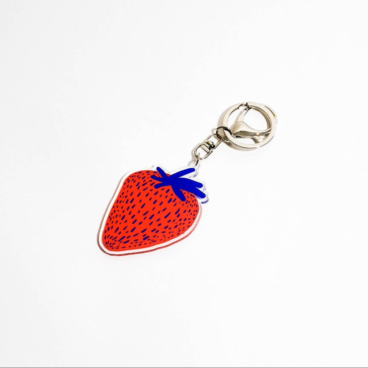 A strawberry-shaped keychain charm with a red body, black seeds, a blue stem, and a silver metal clasp, shown on a plain white background.
