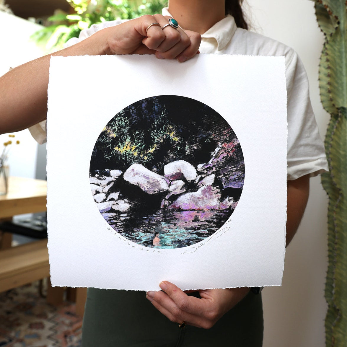 print held by woman with cactus in background.