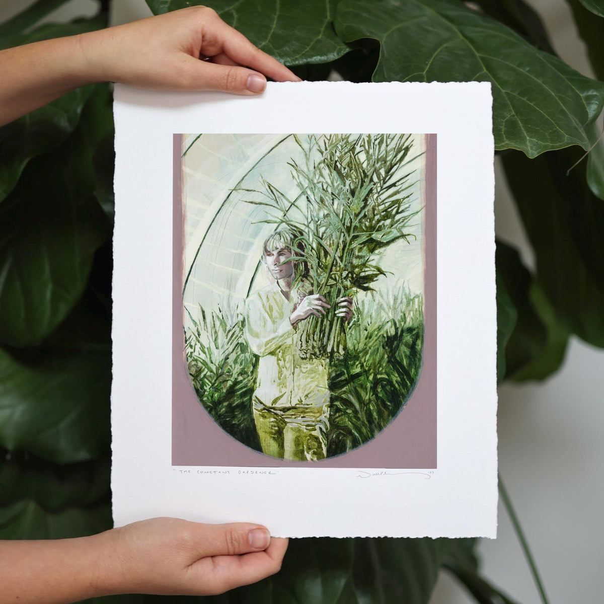 Woman carries tall spring onions through a very green house. 
