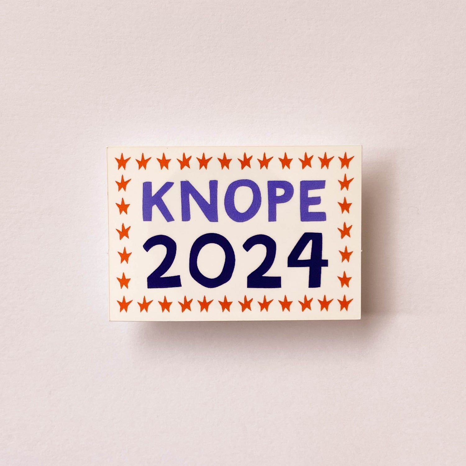 rectangle white sticker with a red star border and words "knope 2024."