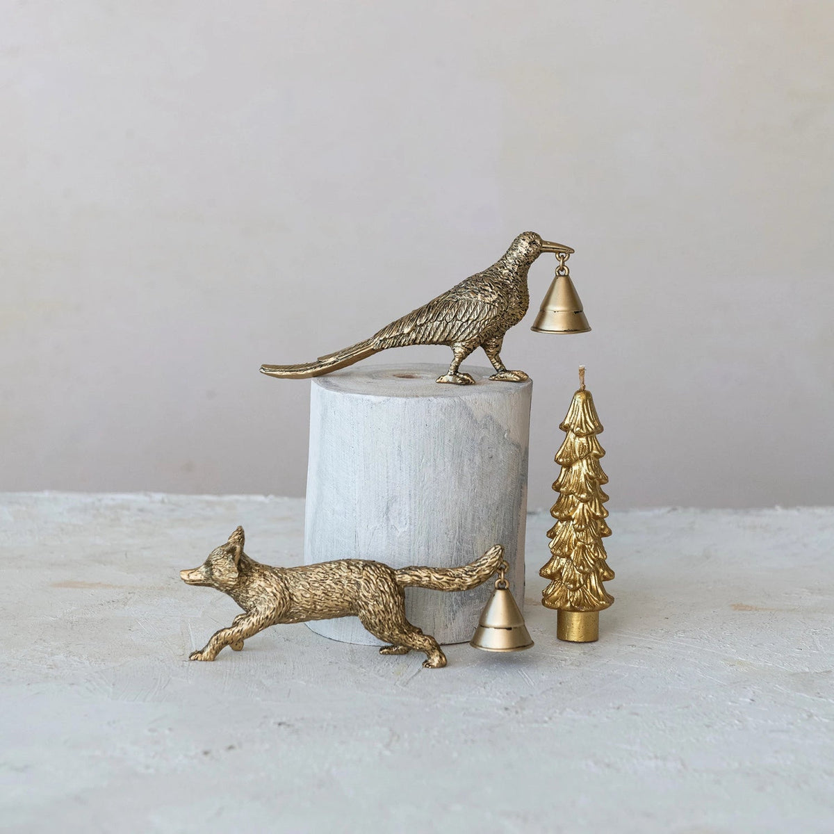 Decorative items including a gold fox, bird, and tree on a marble surface with a neutral background